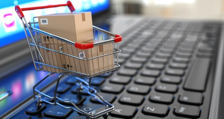 Miniaturowy wózek sklepowy z kilkoma paczkami ustawiony na klawiaturze laptopa symbolizuje rozwój e-commerce i rosnącą popularność platform takich jak Temu. Obraz odzwierciedla proces zakupów online, szybkie dostawy oraz znaczenie marketplace’ów w handlu internetowym.